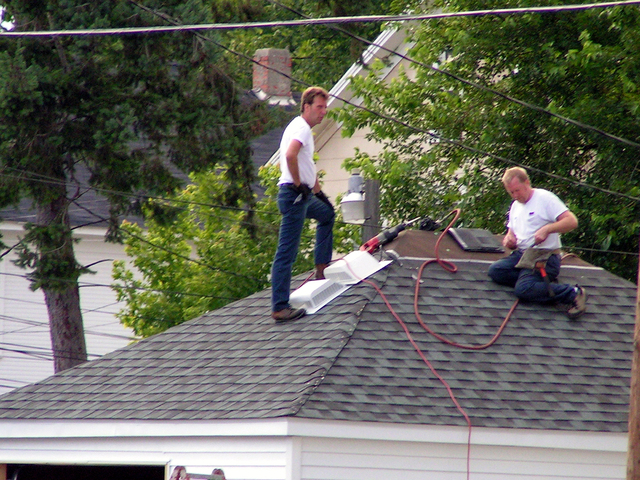 chlápci pracující na střeše domu